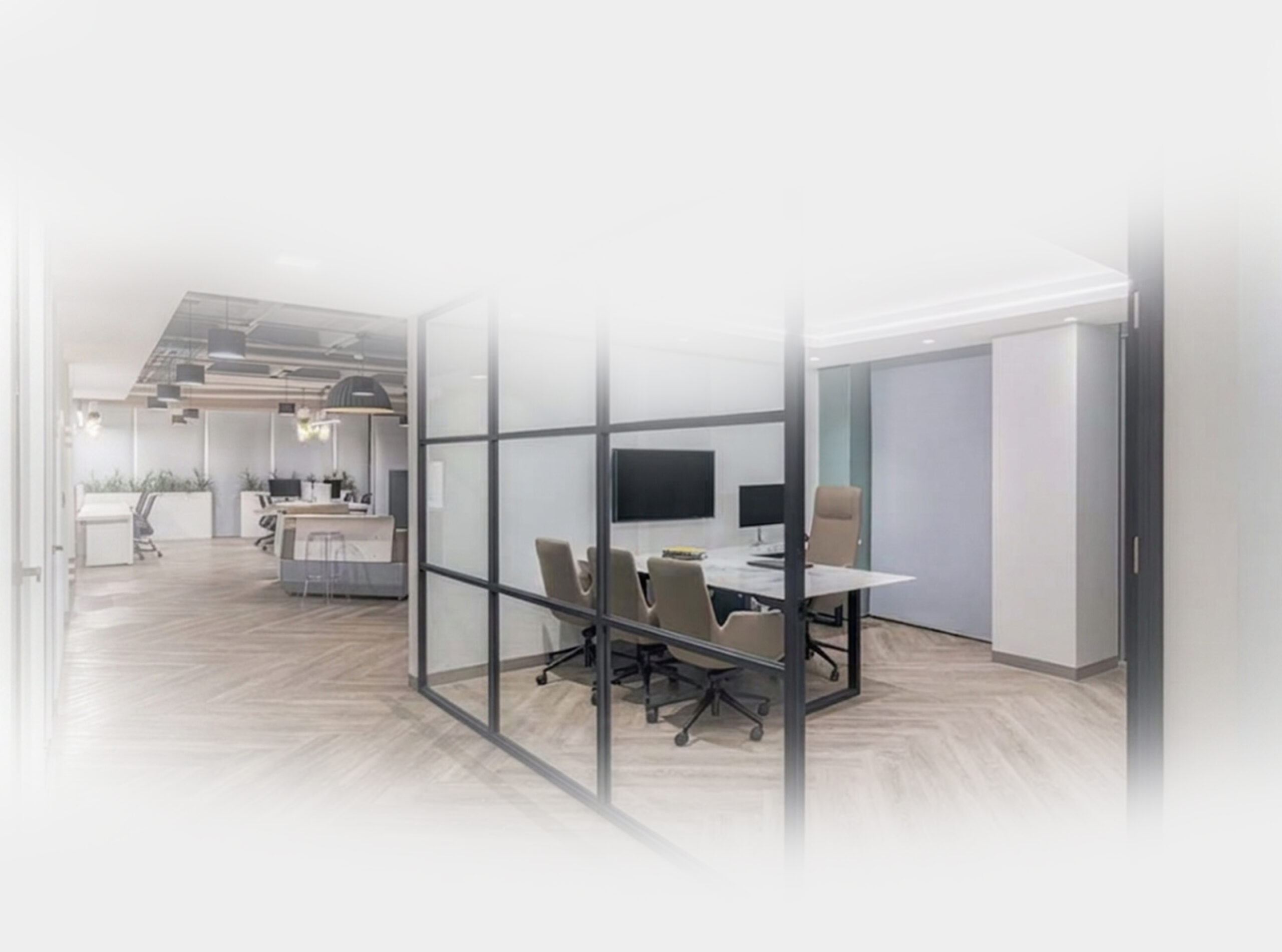 Modern office with a glass-walled meeting room, table with chairs, and an open workspace in the background.
